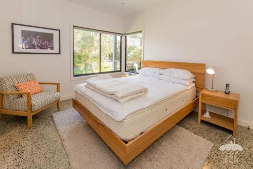 a bedroom with a bed and a chair and a window at 1 Anderson Avenue Sandy Point in Sandy Point