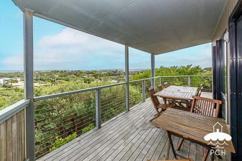 a porch with a wooden table and bench on it at 37 Oceanview Parade Sandy Point in Sandy Point