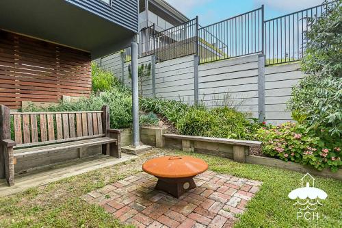 a bench and a stool sitting in a yard at 37 Oceanview Parade Sandy Point in Sandy Point