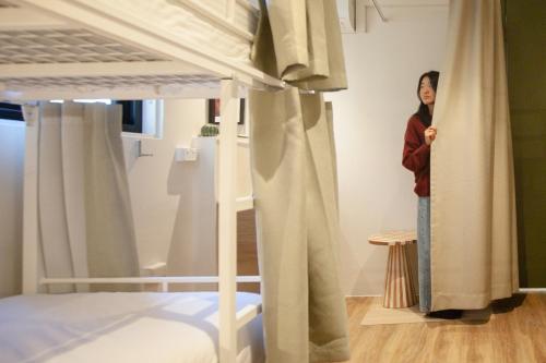 a woman standing in a bedroom looking at a bed at Little Drifter Glebe in Sydney