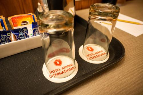 a couple of glass bottles on a black tray at Hotel Asrani International in Secunderabad