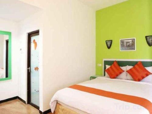 a bedroom with a bed with green and white walls at Oriza Hotel Surabaya in Surabaya