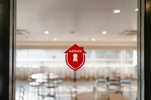 a sign on a door with a room with tables at Hotel Asrani International in Secunderabad