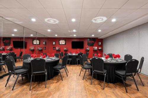 a conference room with tables and chairs and red walls at Wyndham Riverfront Hotel in Little Rock