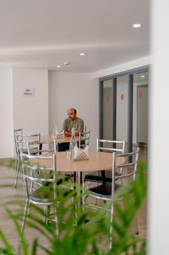 a man sitting at a table in an office at Hotel Asrani International in Secunderabad