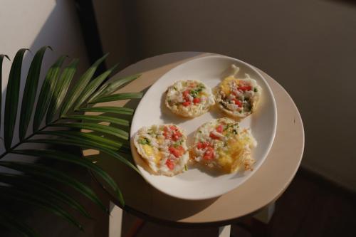 four muffins on a white plate next to a plant at Hotel Asrani International in Secunderabad