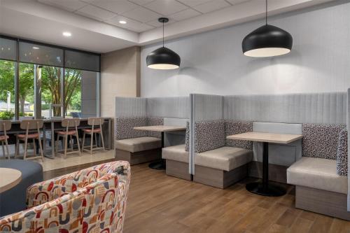 Un restaurante con mesas, sillas y ventanas. en Home2 Suites by Hilton Lexington Park Patuxent River NAS, MD, en Lexington Park