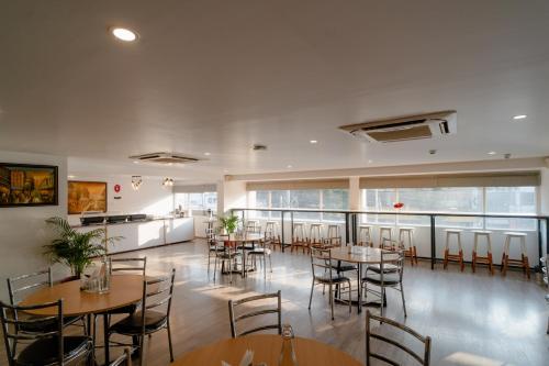 a restaurant with tables and chairs in a room at Hotel Asrani International in Secunderabad