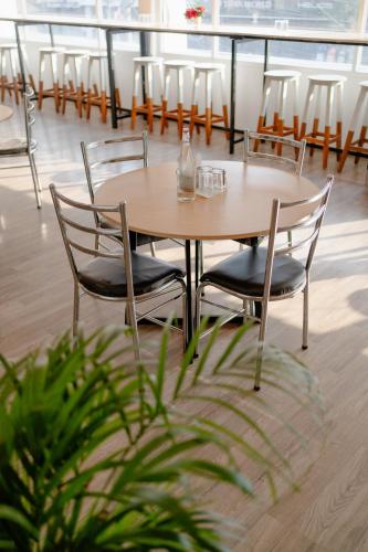 a table and chairs in a room with a plant at Hotel Asrani International in Secunderabad