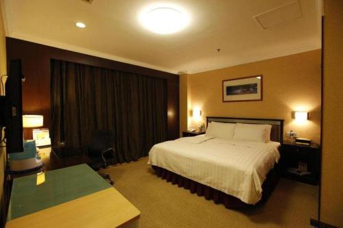 a hotel room with a bed and a desk at Changchun Zhuozhan Days Hotel in Changchun