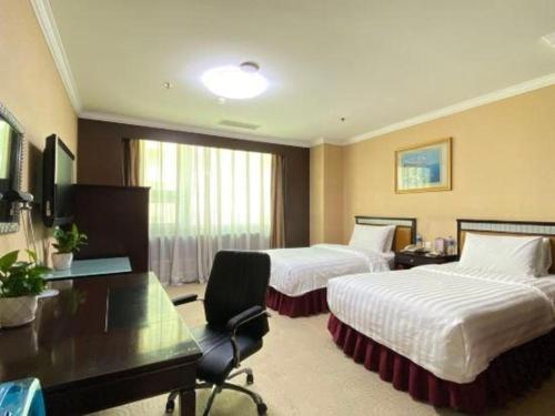 a hotel room with two beds and a desk at Changchun Zhuozhan Days Hotel in Changchun