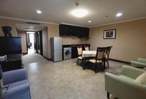 a kitchen and living room with a table and chairs at Changchun Zhuozhan Days Hotel in Changchun