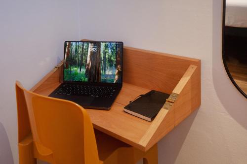 a laptop computer sitting on top of a wooden desk at Little Drifter Glebe in Sydney
