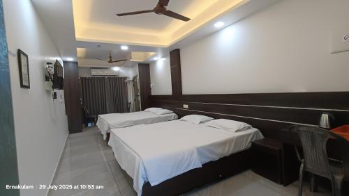a hotel room with two beds and a ceiling at Aroma Serviced Villa Cochin in Ernakulam