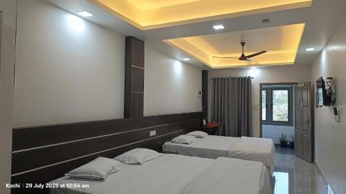 two beds in a room with a ceiling at Aroma Serviced Villa Cochin in Ernakulam