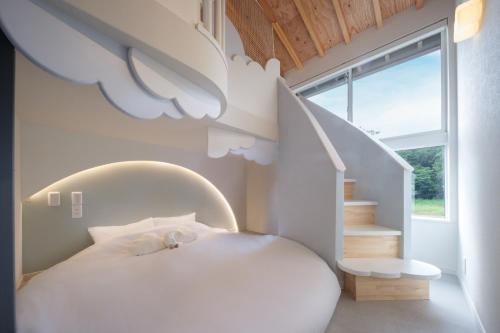 a white bedroom with a white bed and stairs at 遊び場いっぱい Kidsʻ Play Villa 庭付き貸別荘 最大14名 屋根付きBBQ in Kimitsu