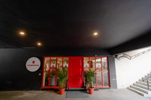 a building with red doors and potted plants outside at Hotel Asrani International in Secunderabad