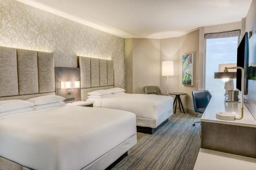 a hotel room with two beds and a television at Hilton DFW Lakes Executive Conference Center in Grapevine