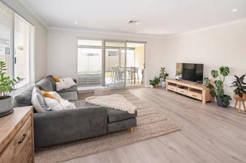 a living room with a couch and a flat screen tv at Jetty Retreat- minutes to town and beach in Busselton