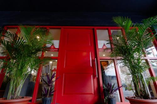 a red door in front of a store with potted plants at Hotel Asrani International in Secunderabad