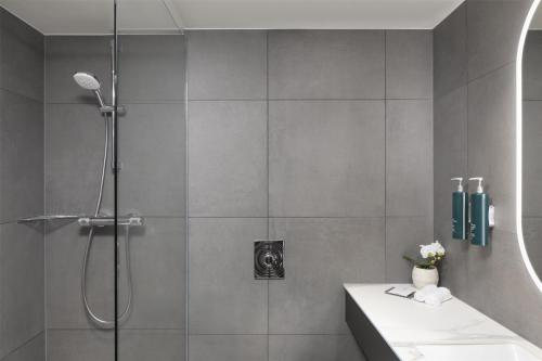a bathroom with a shower and a sink at Hilton Düsseldorf in Düsseldorf