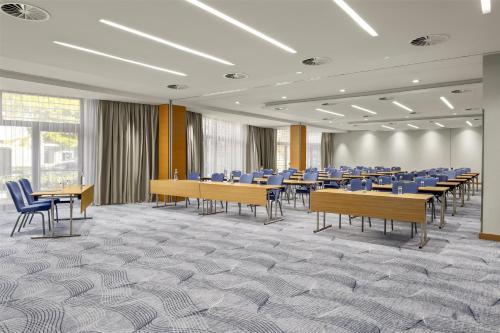 a conference room with desks and chairs and tables at Hilton Düsseldorf in Düsseldorf