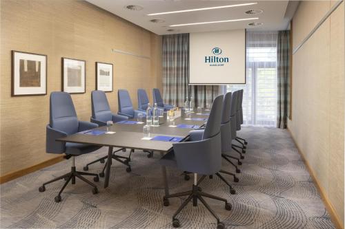a conference room with a long table and chairs at Hilton Düsseldorf in Düsseldorf