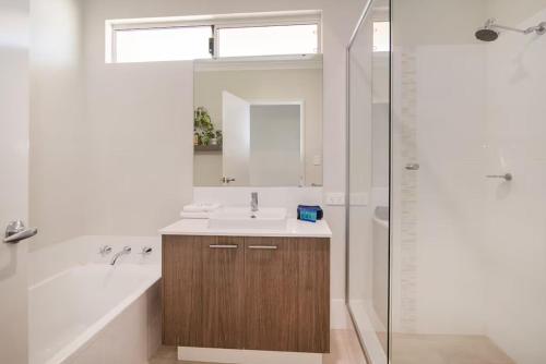 a bathroom with a sink and a tub and a shower at Jetty Retreat- minutes to town and beach in Busselton
