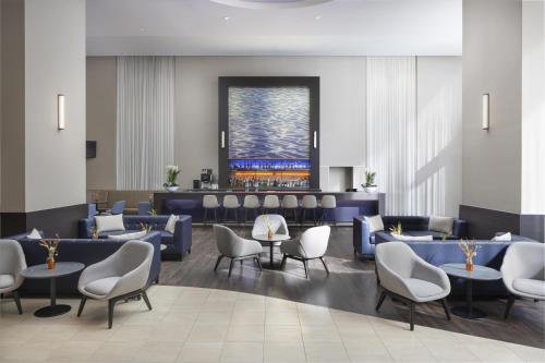 a lobby with chairs and tables and a bar at Hilton Düsseldorf in Düsseldorf