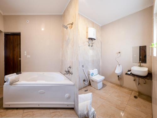 a bathroom with a white tub and a toilet at Amaze Stays Noida Sector 70 in Noida