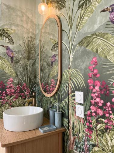 a bathroom with a sink and a wall with flowers at LA SEIGNEURIE DE TILLAC in Tillac