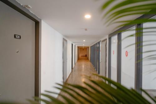 a hallway in an office building with a plant at Hotel Asrani International in Secunderabad