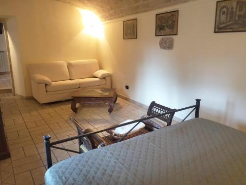 a room with a bed and a couch and a table at il cortile in Calascio