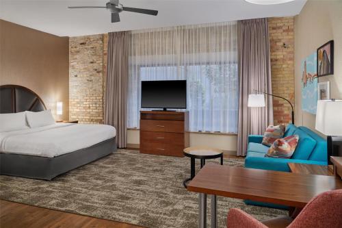 a hotel room with a bed and a tv at Homewood Suites by Hilton Grand Rapids Downtown in Grand Rapids