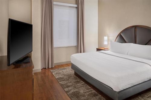 a bedroom with a bed and a flat screen tv at Homewood Suites by Hilton Grand Rapids Downtown in Grand Rapids