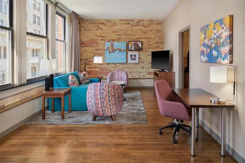a living room with a couch and chairs and a desk at Homewood Suites by Hilton Grand Rapids Downtown in Grand Rapids