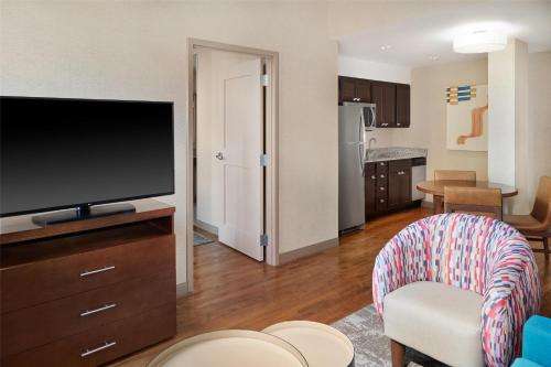 a living room with a flat screen tv and a kitchen at Homewood Suites by Hilton Grand Rapids Downtown in Grand Rapids