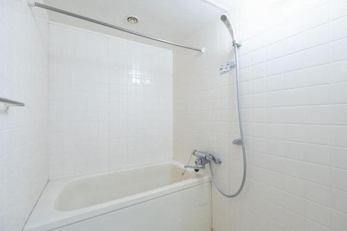 a white bathroom with a tub and a shower at Fujiterrace Yoga in Tokyo