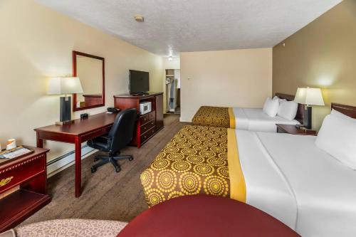 a hotel room with two beds and a desk at Econo Lodge Inn & Suites High Level in High Level