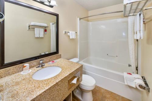 a bathroom with a sink and a tub and a toilet at Econo Lodge Inn & Suites High Level in High Level