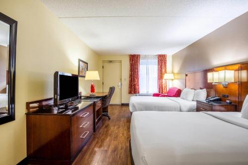 a hotel room with two beds and a flat screen tv at Econo Lodge Naval Station Norfolk in Norfolk