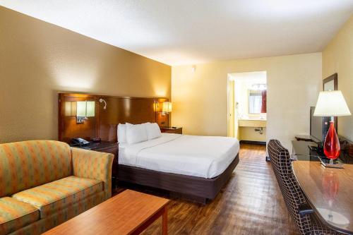 a hotel room with a bed and a couch at Econo Lodge Naval Station Norfolk in Norfolk