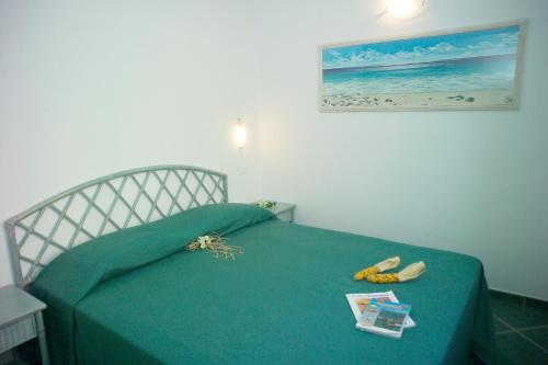 a bedroom with a green bed with two bananas on it at Appartamenti Tallinucci in Lacona