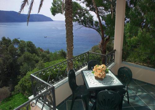 a table and chairs on a balcony with a view of the water at Appartamenti Tallinucci in Lacona