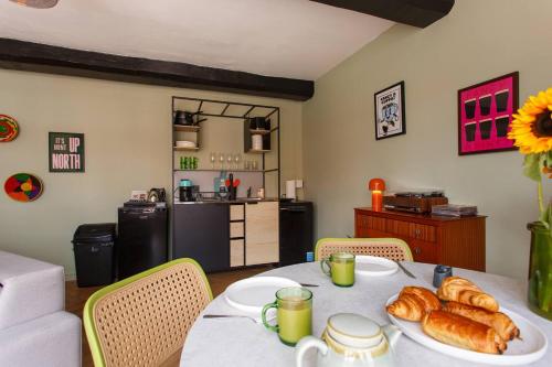 a table with a plate of croissants and a kitchen at Curated 1BR Apartment with City Views & Central! in Chester