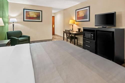 a hotel room with a bed and a flat screen tv at Quality Inn & Suites - Granbury in Granbury