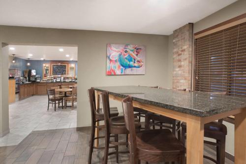 een keuken en eetkamer met een tafel en stoelen bij AmericInn by Wyndham Mount Pleasant in Mount Pleasant