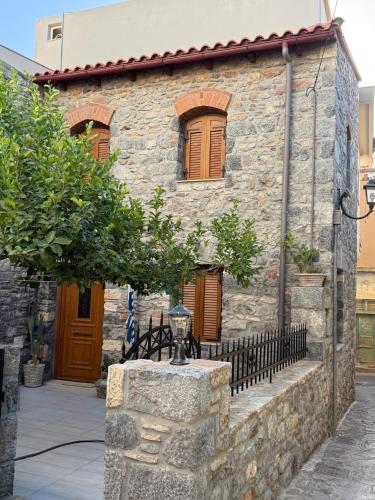 a stone house with a tree in front of it at Villa GIANNAKOS MINOAN HERSONISSOS in Kastéllion