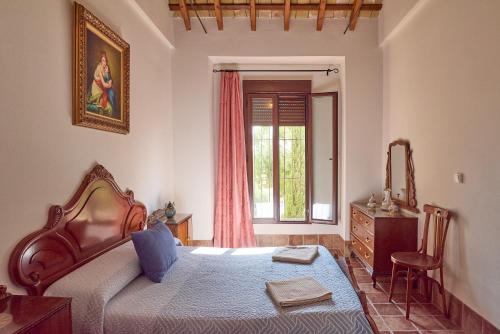 a bedroom with a bed and a dresser and a window at Vivienda Turística Rural Santa Fe in Montilla