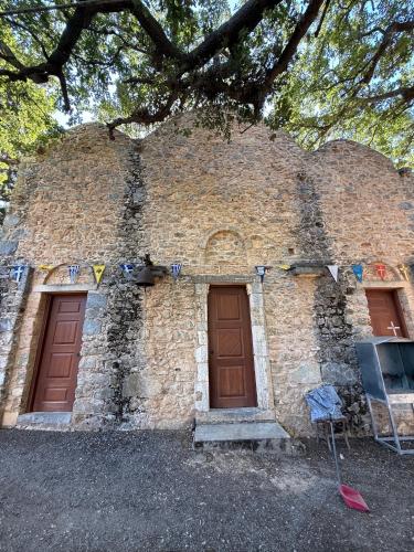 a brick building with two doors and a tree at Villa GIANNAKOS MINOAN HERSONISSOS in Kastéllion
